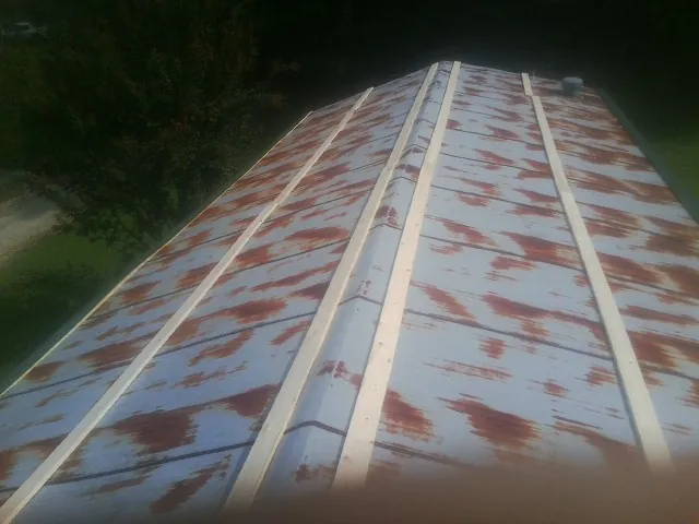 Rusted metal roof panels with new wood purlins before replacement — Storm Damage Roof Repair in Orgas by Roofing Brothers